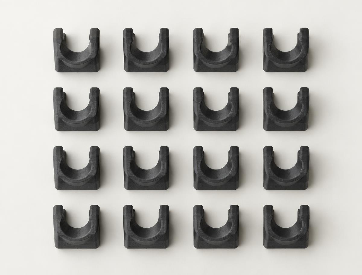 Grid of identical charcoal 3D printed clips